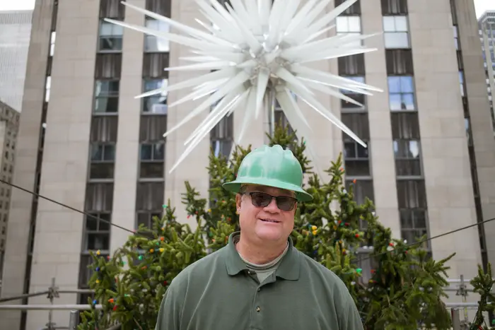 Erik Pauze stands before the top of the Rockefeller Center Christmas Tree.